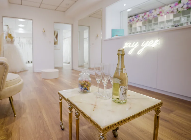 Einladender Sitzbereich der SAY YES Boutique mit beleuchtetem Schriftzug und gedecktem Tisch