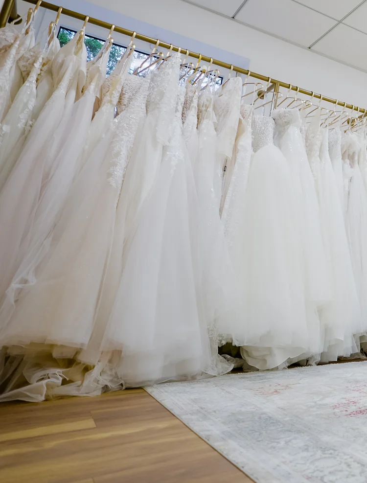Brautkleider auf goldenen Kleiderstangen im Showroom von SAY YES